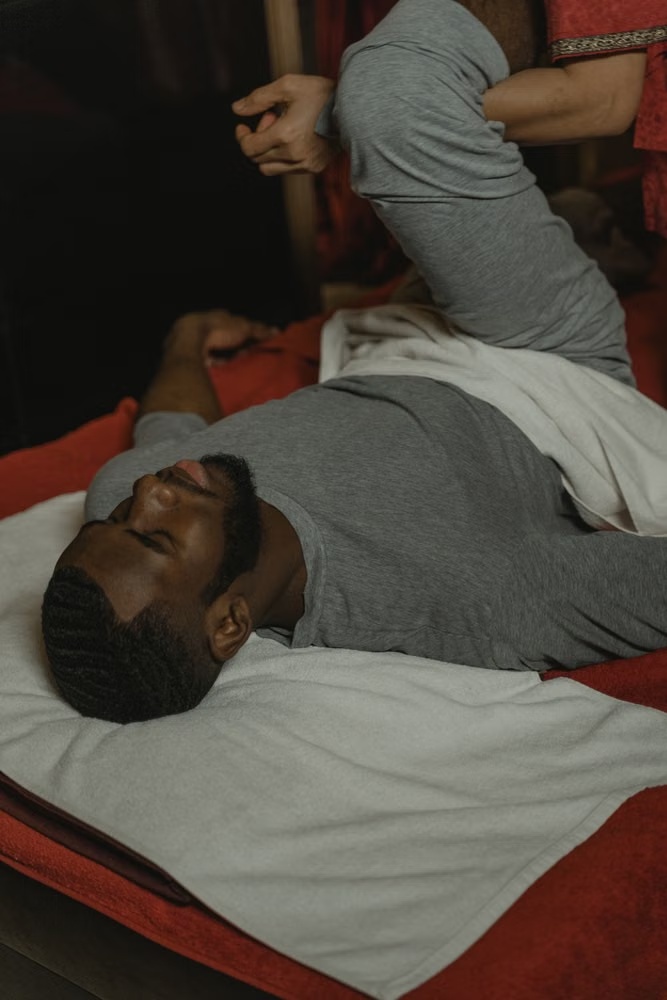 Therapist assisting a client's leg stretch during a sports massage session